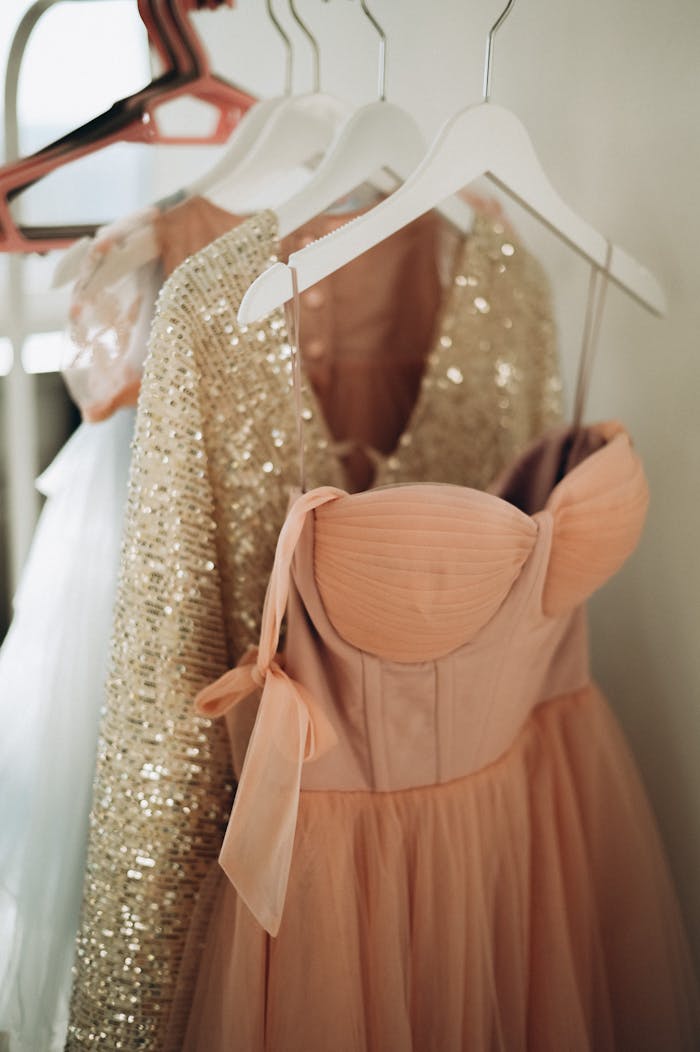 services-02 Peach and sequin dresses hanging elegantly on coathangers, perfect for fashion inspiration.