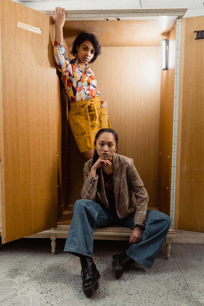 The Art of Drawing Readers In: Your attractive post title goes here Two fashionable women pose stylishly in a wooden closet setup indoors.